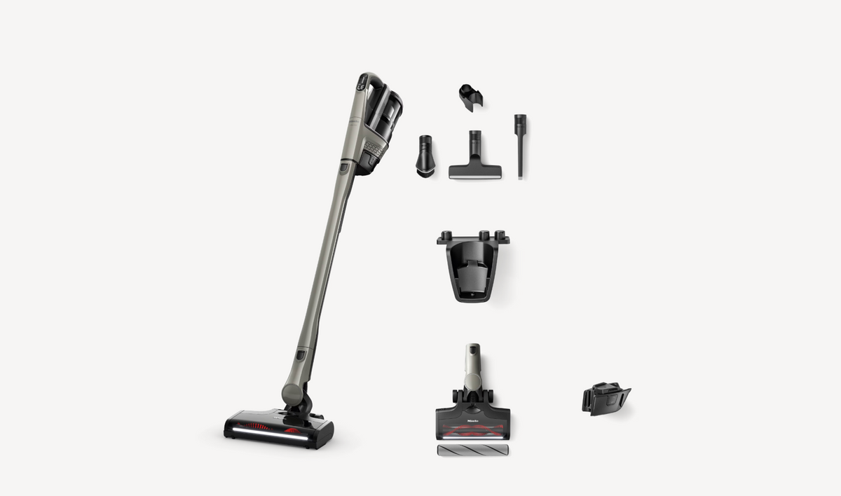 A cordless stick vacuum cleaner with multiple attachments and accessories arranged neatly on a clean white background.