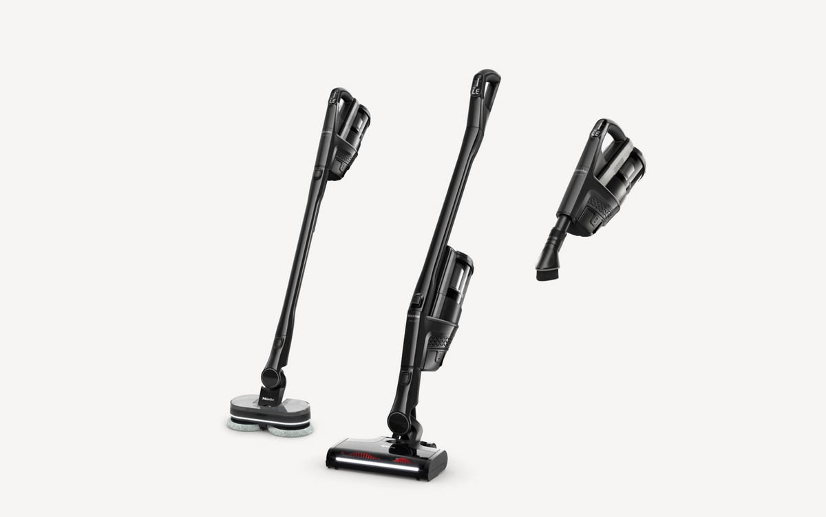 Three views of a cordless stick vacuum cleaner in black and gray, shown on a clean white background.