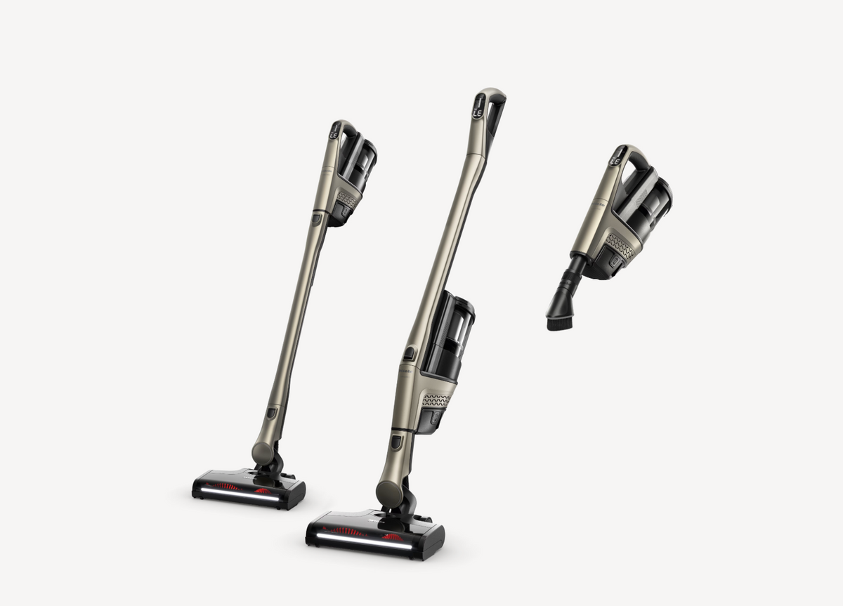 Three views of a cordless stick vacuum cleaner in a metallic taupe-gray and black color scheme, displayed on a clean light gray background.