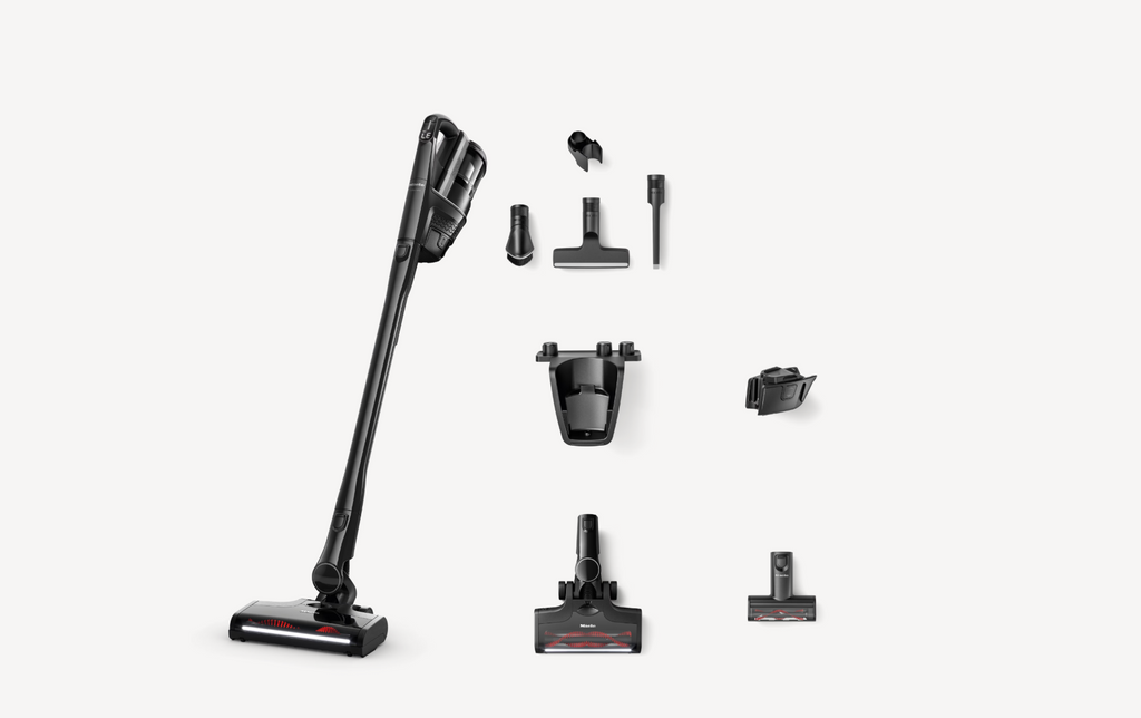 A cordless stick vacuum cleaner shown with multiple attachments and accessories arranged on a light gray background.
